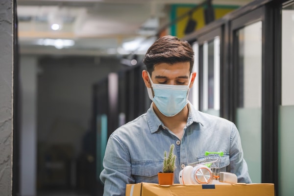 giovane con mascherina affronta la perdita del lavoro come opportunità