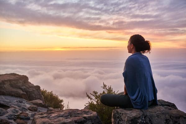 ragazza guarda l'orizzonte al tramonto dopo aver dato le dimissioni per ricercare un nuovo lavoro