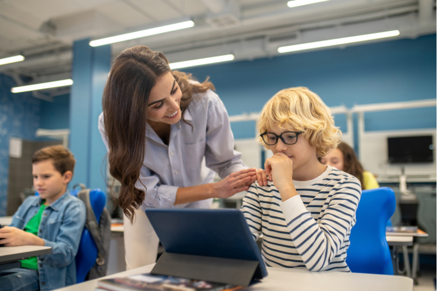 docente_aiuta_alunno_nel_conoscere_se_stesso docente aiuta uno studente in classe per capire le sue preferenze per il futuro